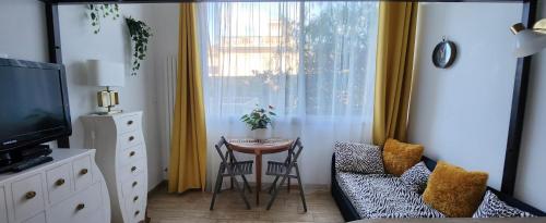 salon ze stołem i krzesłami oraz oknem w obiekcie STUDIO- NICE MONT BORON, PISCINE SUR LA RESIDENCE w Nicei