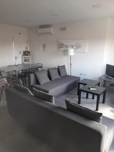 a living room with a couch and a table at TOLETUM low cost LOFTS diáfanos o 2dormitorios PARKING Municipal Gratis al aire libre a 100m in Toledo
