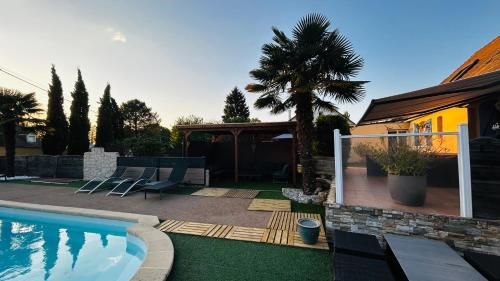 une cour arrière avec une piscine et une maison dans l'établissement Circuit des 24H du Mans - 8 personnes, à Brette-les-Pins