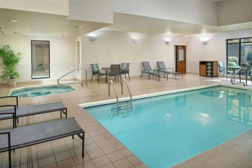 a pool in a hotel room with tables and chairs at Fairfield by Marriott Inn & Suites Asheville Outlets in Asheville