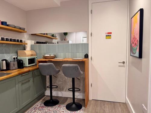 a kitchen with two stools in front of a counter at 40th Avenue Guest House in Mill Hill