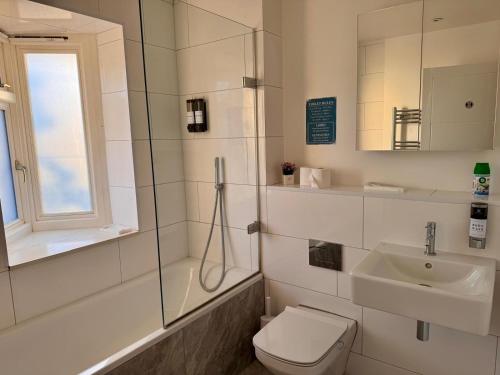 a bathroom with a toilet and a sink at 40th Avenue Guest House in Mill Hill