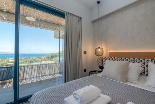 a bedroom with a bed and a view of the ocean at Nusa Retreat - Seaview luxury residences in Kissamos