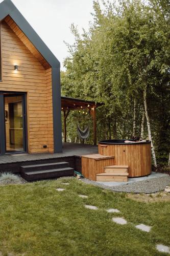 a house with a hot tub in the yard at Czill-Lokum- klimatyczna chata w Beskidach z balią i sauną in Maków Podhalański