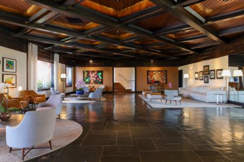 a large lobby with white chairs and tables at Sanma Hotel in Foz do Iguaçu