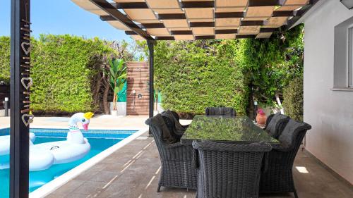 a patio with a table and chairs next to a pool at Villa Talya in Peyia