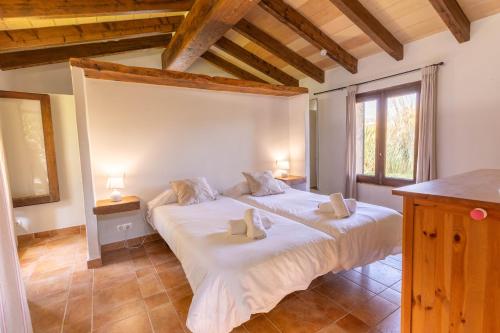 a bedroom with two beds and two windows at Charming villa with A/C and WIFI in Pollença