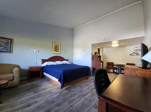 Un dormitorio con una cama, un sofá y una mesa. en Welcome Inn and Suites, en Saint Johns