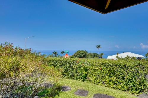 a view of a garden with the ocean in the background at Kona Coast Hideaway with Patio and Pacific Ocean Views in Kailua-Kona