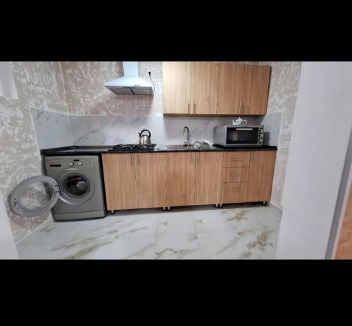 a kitchen with a stove and a sink and a microwave at Guesthouse Family in Gergeti