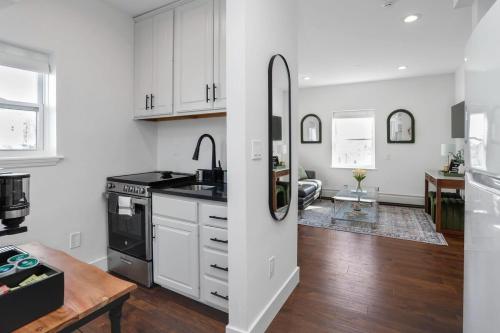 スタンフォードにあるLuxury, Modern 2BR, Harbor Pointのキッチン(白いキャビネット、黒いカウンタートップ付)