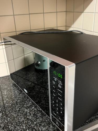 a microwave oven with a clock on top of it at Ruvuka Retreat in Vosburg