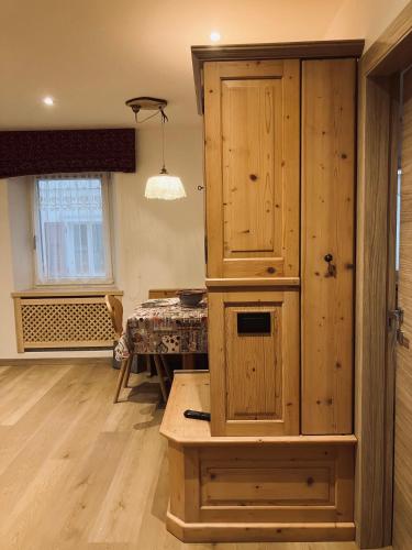 a large wooden cabinet in a room with a table at CERMIS Minisuite in Cavalese