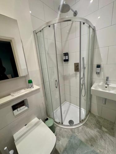 a bathroom with a shower and a toilet and a sink at 40th Avenue Guest House in Mill Hill