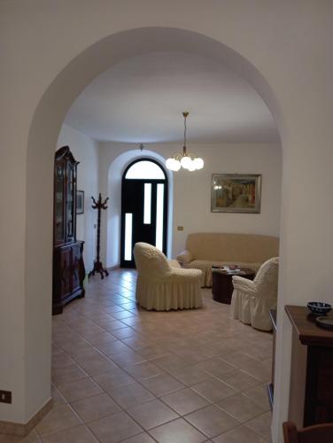a living room with a couch and chairs and an archway at Casa Vacanze Mily in Scheggia e Pascelupo