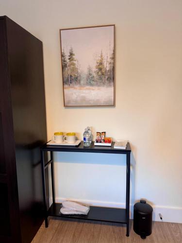 a black table with bowls and cups on it at 40th Avenue Guest House in Mill Hill