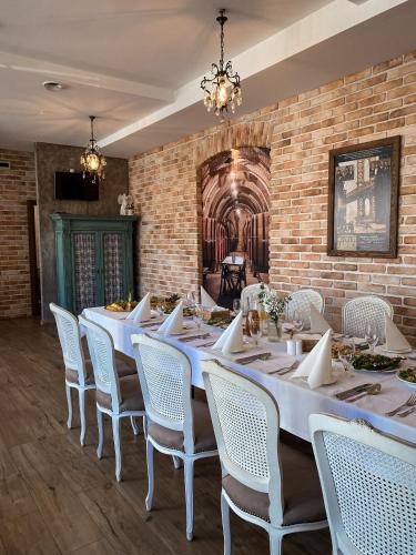 a dining room with a long table and white chairs at Gościnna Prowansja in Łuków