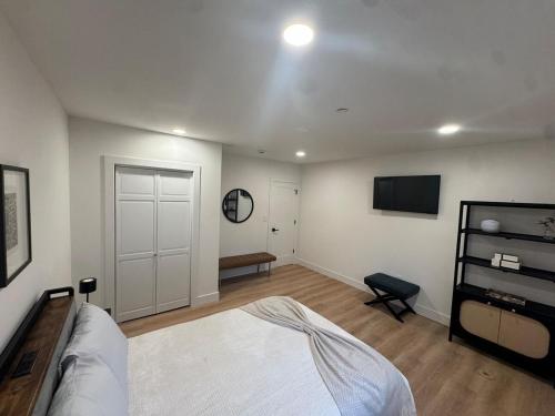 a bedroom with a bed and a tv on the wall at Stylish 3BR,2BA in Heart of Harbor Point in Stamford