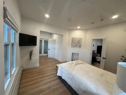 a bedroom with a bed and a flat screen tv at Stylish 3BR,2BA in Heart of Harbor Point in Stamford