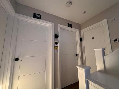a room with two white doors with numbers on them at 40th Avenue Guest House in Mill Hill