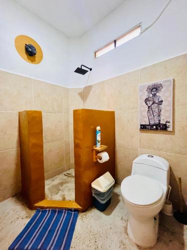 a bathroom with a white toilet and a blue rug at Palmar la Punta 8 AC Starlink 2min walk to beach in Brisas de Zicatela