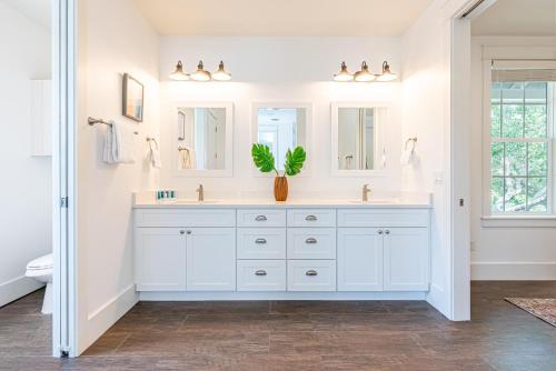 ein Badezimmer mit weißen Schränken und einer Topfpflanze in der Unterkunft 9 E Willow Mist in Preserve at Inlet Beach in Inlet Beach