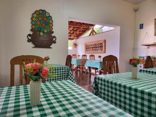 a restaurant with green and white tables with flowers in vases at Pousada Do Ó in Tiradentes