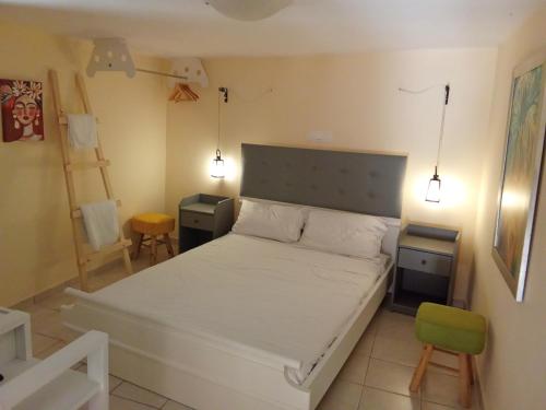 ein Schlafzimmer mit einem Bett, einem Stuhl und Lampen in der Unterkunft Bezari pool villa in Metochia Fratzeskiana