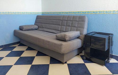 a brown couch sitting in a room with a television at One-Bedroom Apartment In La Pobla De Farnals in Masalfasar