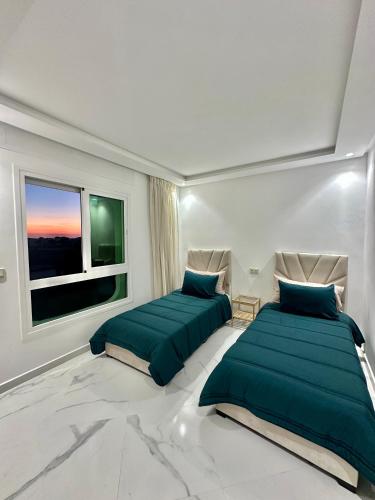 a bedroom with two beds and a window at Achakar Hill in Tangier