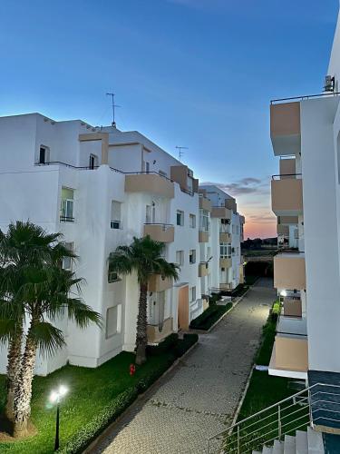 a large white building with palm trees in front of it at Achakar Hill in Tangier