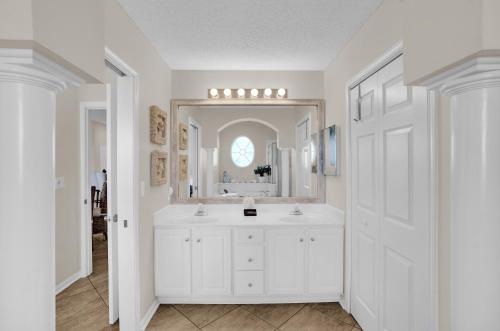 a white bathroom with a sink and a mirror at 305 West in Gulf Highlands