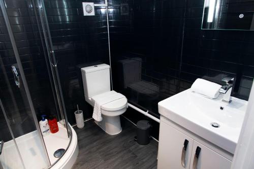 a bathroom with a toilet and a shower and a sink at Snuggle Cove Apartments- Walton Road in Liverpool