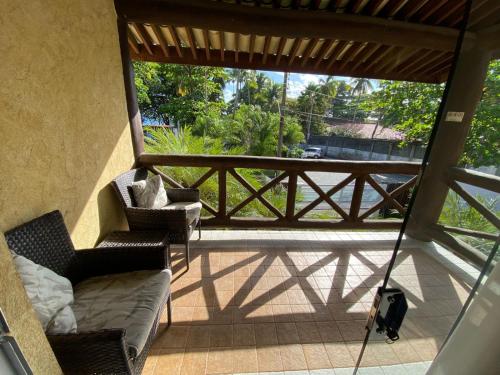 a porch with two chairs and a couch on a balcony at Iara Beach Hotel Boutique in Salvador