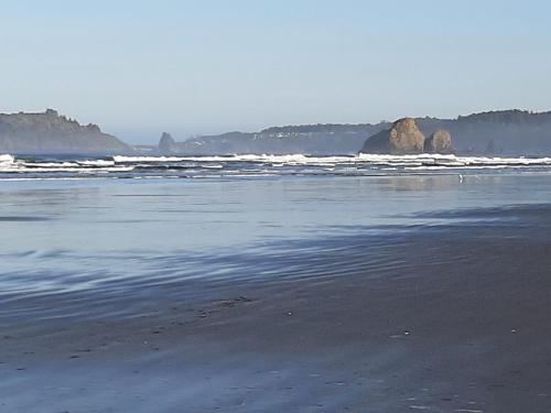 a beach with waves and rocks in the ocean at Trillium Bungalow in Arcata in Arcata