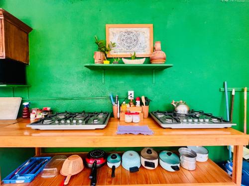 a kitchen counter with a stove and a green wall at Palmar la Punta 8 AC Starlink 2min walk to beach in Brisas de Zicatela