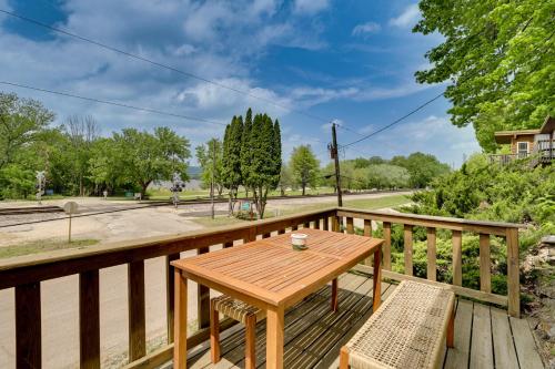 a wooden deck with a wooden table and two benches at Walk to Wyalusing Beach Cabin with River View! in McGregor