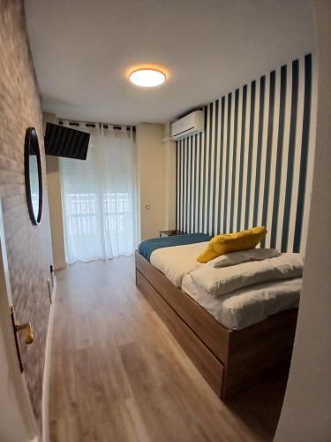 a bedroom with a bed with a yellow pillow on it at Hotel Mexico in Madrid