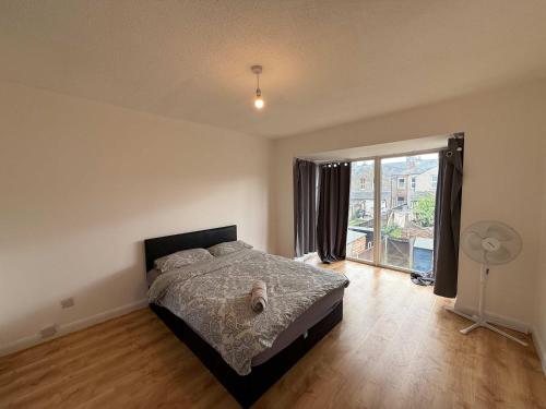 a bedroom with a bed and a large window at Chelmsford 5 Bedroom Large House with Garden & Parking in Chelmsford