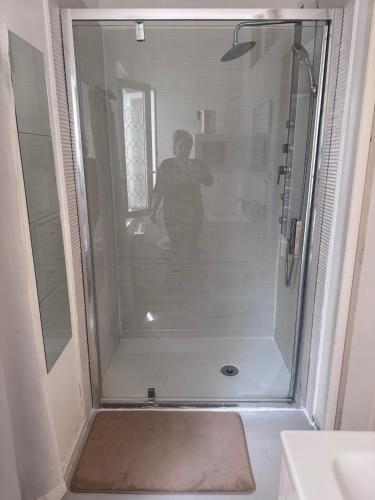a woman standing in a shower in a bathroom at Le Farges-Chambre en colocation-Appartement partagé à 3min de La Gare ST Roch-LaConciergerieByNina in Montpellier