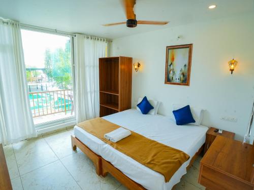 a bedroom with a bed and a large window at Lake view Resort cherai in Cherai Beach