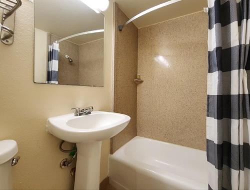 Un baño con lavabo, espejo y ducha. en Welcome Inn and Suites, en Saint Johns