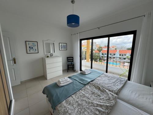 une chambre avec un lit et une grande fenêtre dans l'établissement Apartment Lindamar, à Lagos