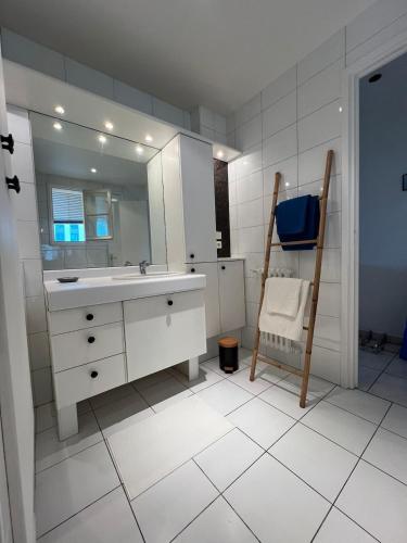 une salle de bain avec un lavabo, un miroir et une chaise dans l'établissement Bright and spacious 1 bedroom apartment with sofa bed in living room , French Riviera, à Saint-Laurent-du-Var