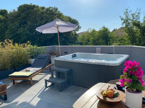 a hot tub on a patio with an umbrella at Studio apartment Dalmatia in Nin