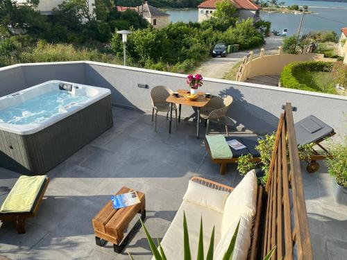 a patio with a hot tub and a table and chairs at Studio apartment Dalmatia in Nin
