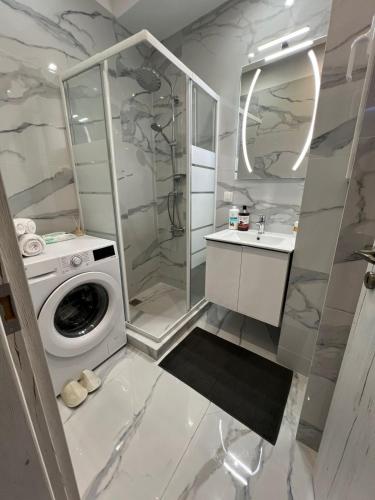 a white bathroom with a washing machine and a sink at Zea Sea View Apartment in Piraeus