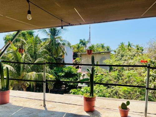 a view of a balcony with plants and trees at Palmar la Punta 8 AC Starlink 2min walk to beach in Brisas de Zicatela