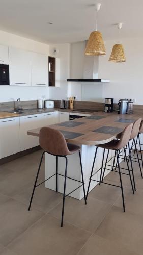 - une cuisine avec une table et trois chaises dans l'établissement Porticcio - appartement T3, à Albitreccia