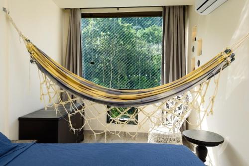 a hammock in a bedroom with a window at St Luxo Copacabana Beach and Metro in Rio de Janeiro